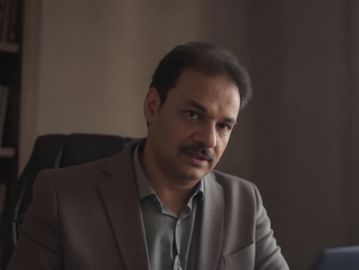 Man in a suit sitting in an office.