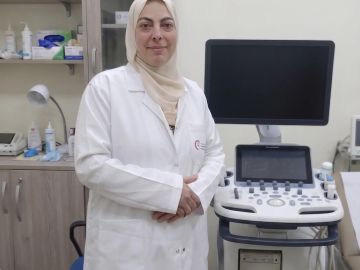 Woman doctor standing next to medical equipment.