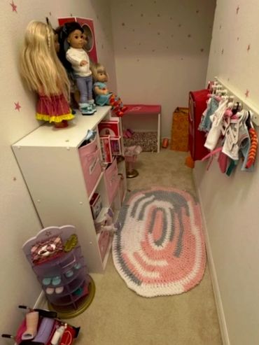 A newly organized playroom and toy closet with dolls and toys neatly arranged.
