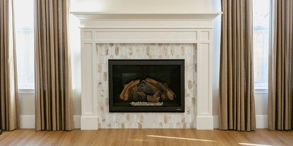 Modern fireplace with wooden logs and curtains.