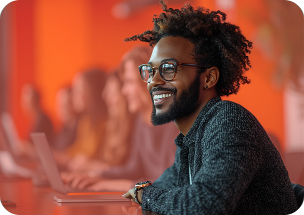 A man in glasses smiles while collaborating, representing co-creating content