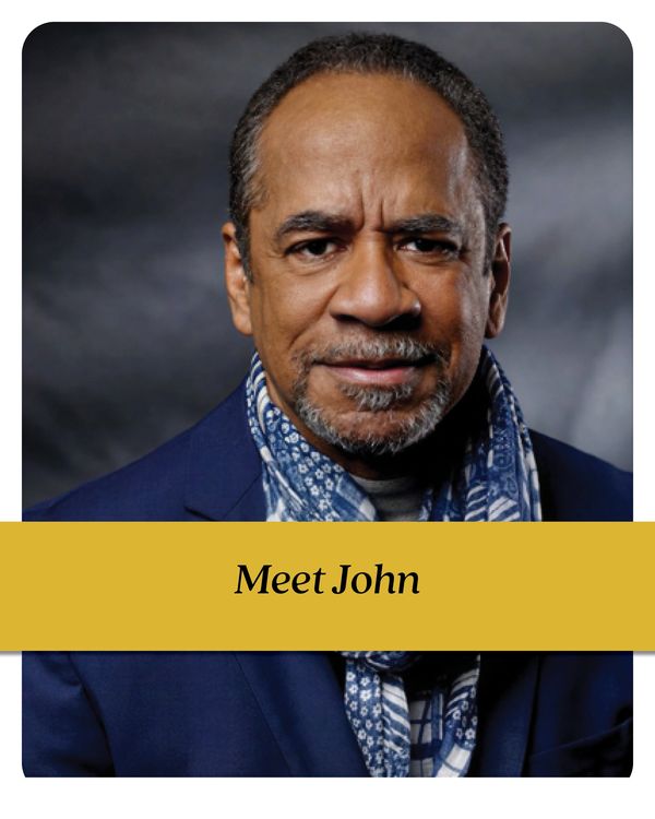 Portrait of a middle-aged man named John wearing a blue scarf and suit jacket.