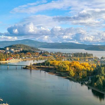 Scenic view of a lakeside town with autumn colors and mountains.