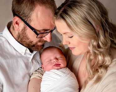 proud parents gazing down at newborn baby