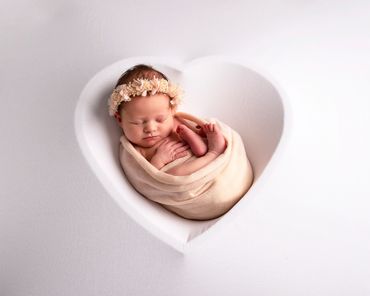 sleeping newborn baby girl in a heart silhouette