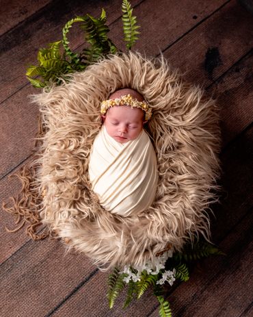 sleeping newborn baby in bed of fur