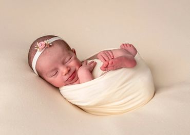 smiling newborn curled up