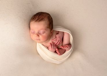 newborn baby curled up sleeping