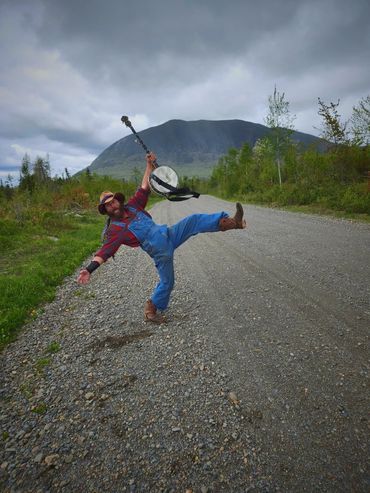 banjo player crossing a dirt road