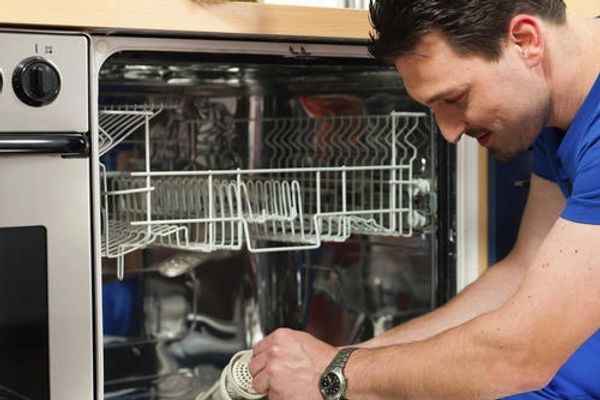Appliance repair technician fixing dishwasher