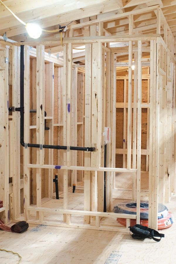 Wooden framing and plumbing installation in a house under construction.