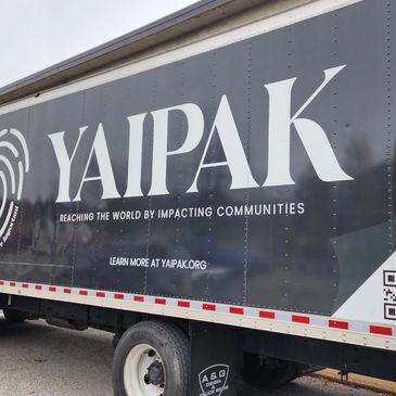 Truck with YAIPAK branding promoting community impact.