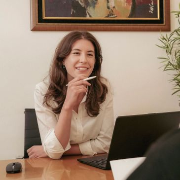 Woman smiling while working on a laptop.