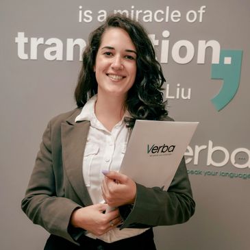 Smiling woman holding a folder in front of a language service company logo.