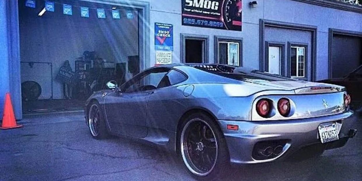Silver Ferrari parked outside a smog check center.