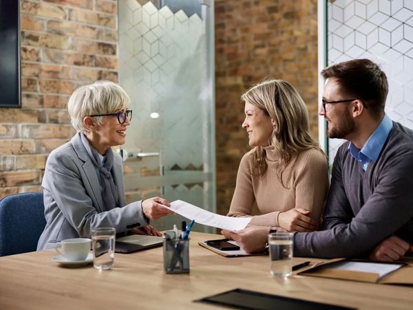 Agent handing papers to clients
