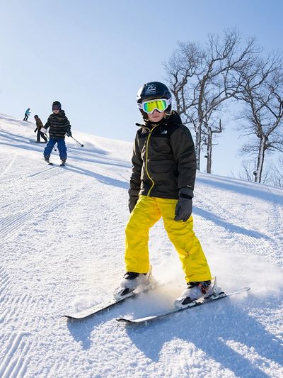 Youth wearing a helmet while skiing