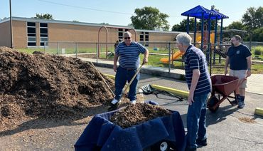 Volunteers helping spread mulch & Pea Gravel