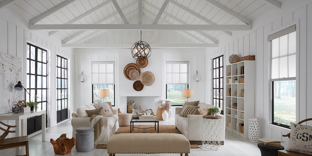 Bright Lutron Living Space with white rafters, tall windows, and sheer roller shades.