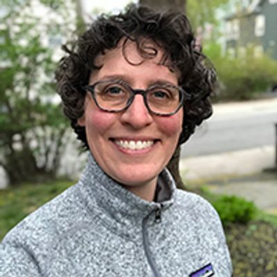 Head and shoulders image of Hannah Weisman wearing a gray jacket and smiling.