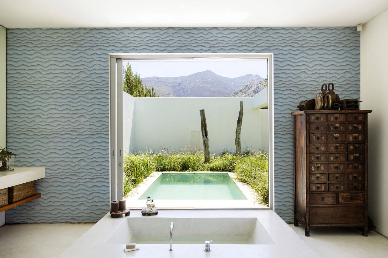 3D wall art panels on wall in bathroom with view to outside pool and mountains
