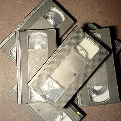 A pile of old VHS tapes stacked randomly.