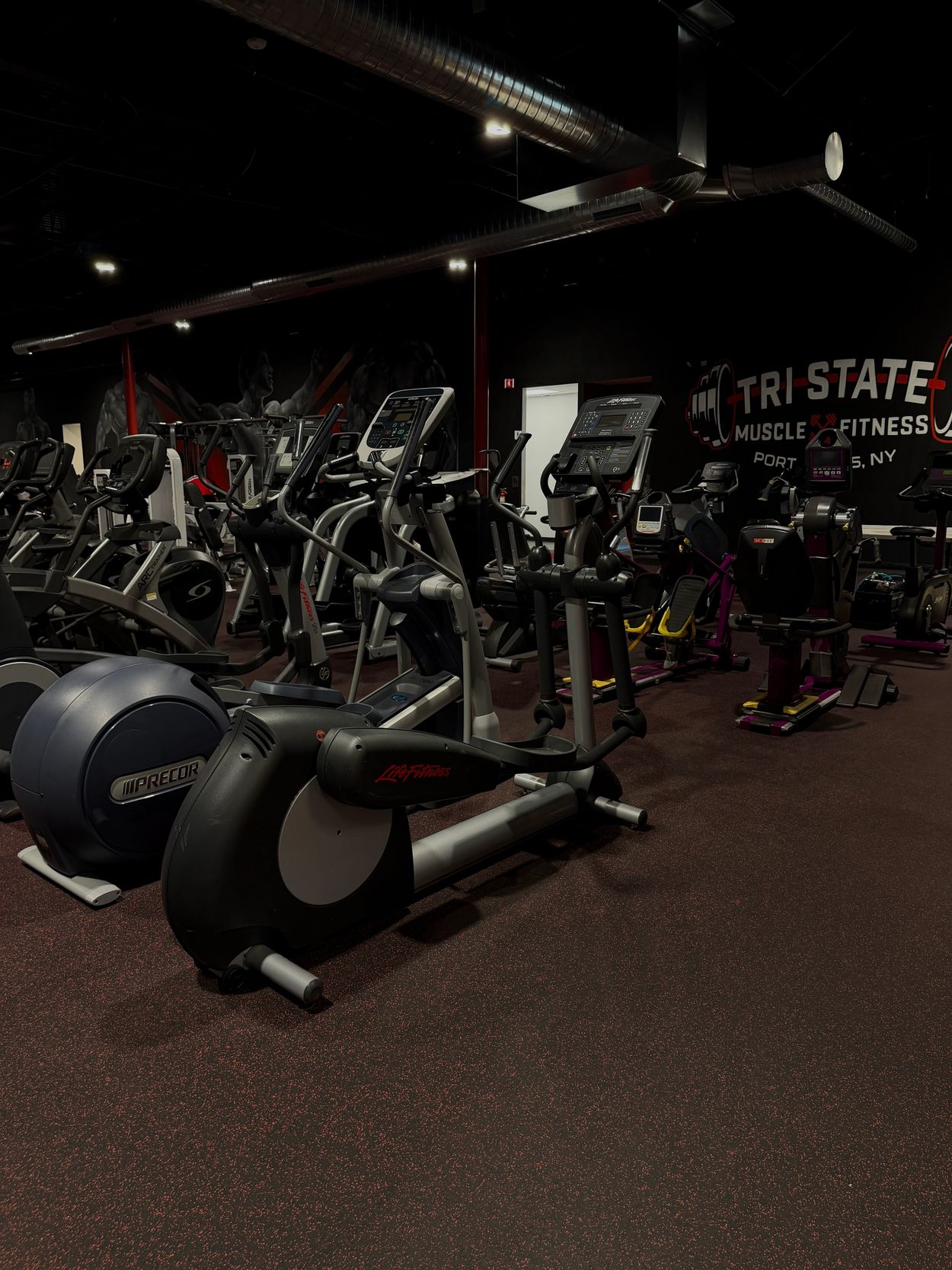 Gym workout machines in a dimly lit fitness center.
