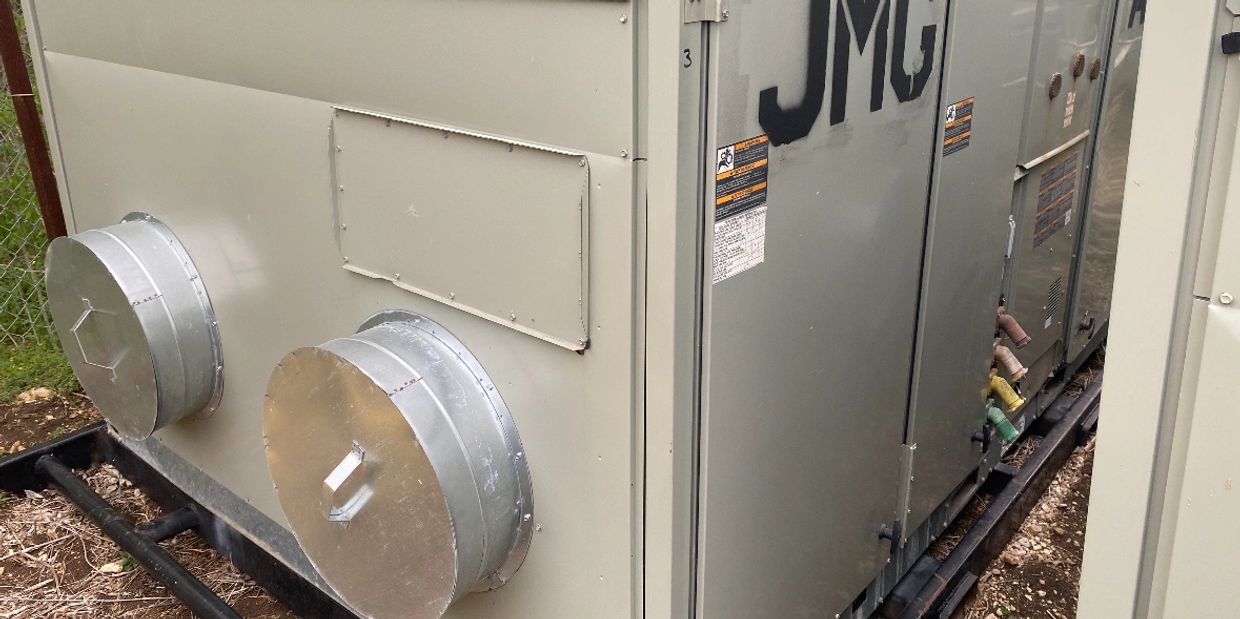 Outdoor industrial HVAC unit with duct covers.