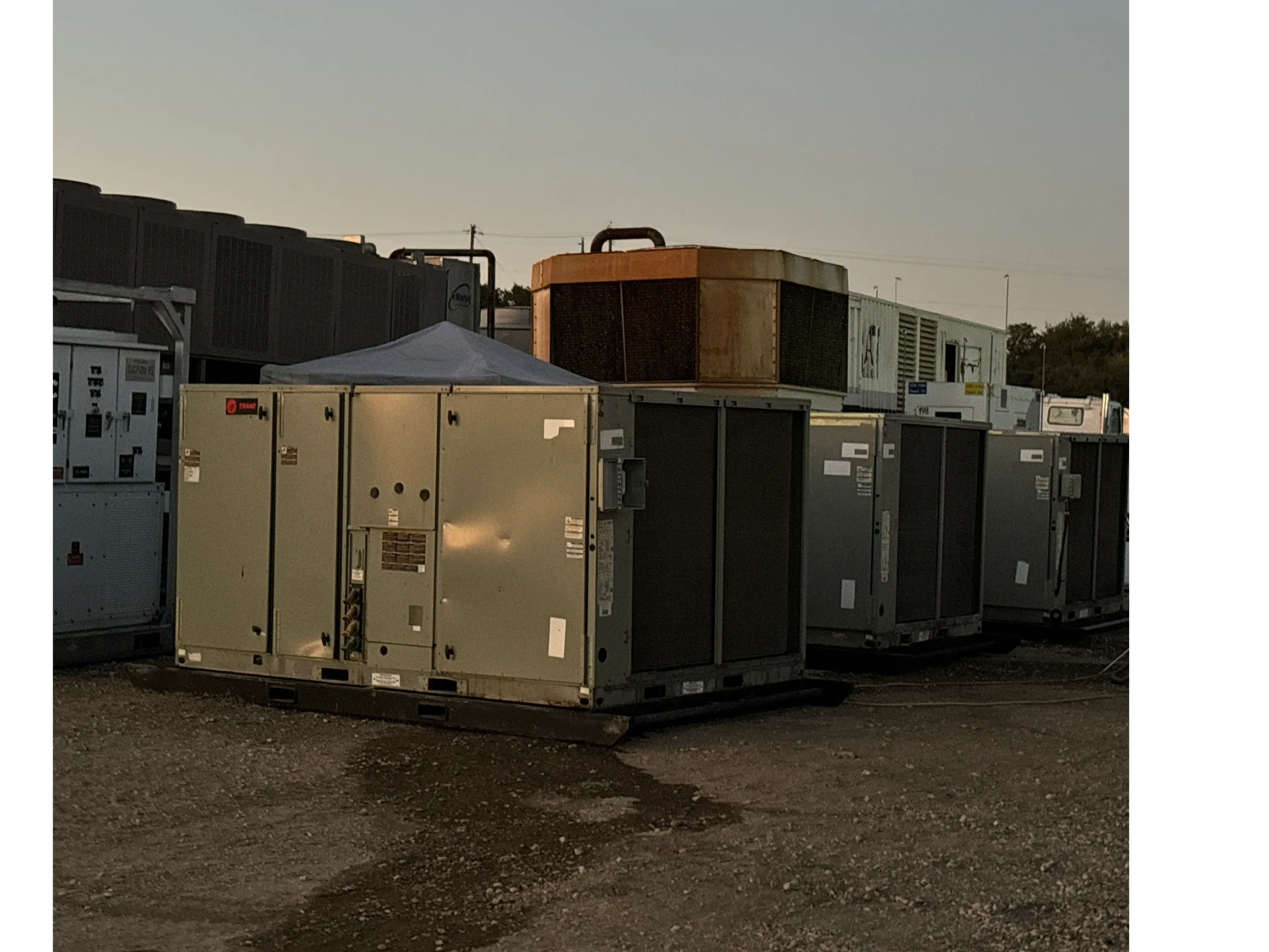 Industrial air conditioning units outdoors at dusk.