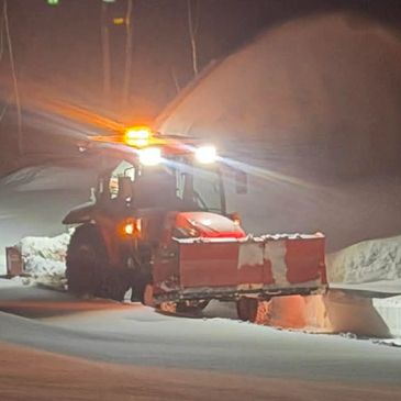 Tracteur déblayant la neige la nuit.