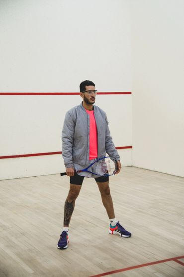 José in a squash court wearing a grey & pink mostly Adidas outfit. Photo:Juanes Montes @ilretallack