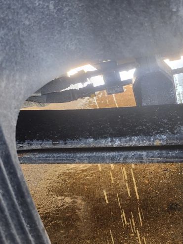 Water leaking and dripping from pipes under a vehicle.