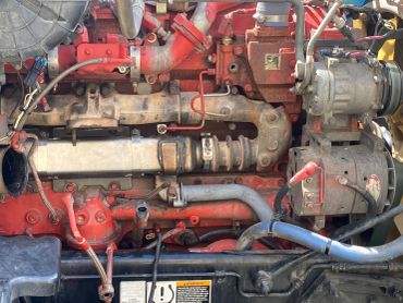 Close-up of a red diesel engine with visible pipes and components.