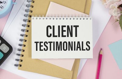 Notepad with 'Client Testimonials' text surrounded by office supplies.