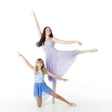 Two girls performing ballet poses in pastel dresses against a white background.
