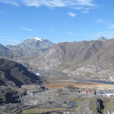 Mountainous landscape with a mining site under a clear sky.