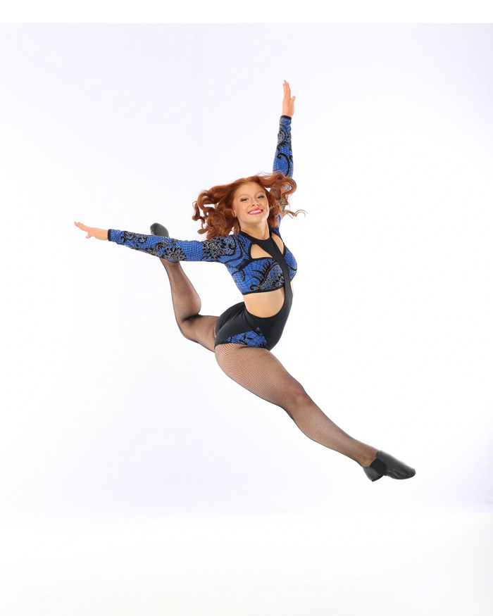 Girl with long red hair in blue and black dance uniform dance posing against white background