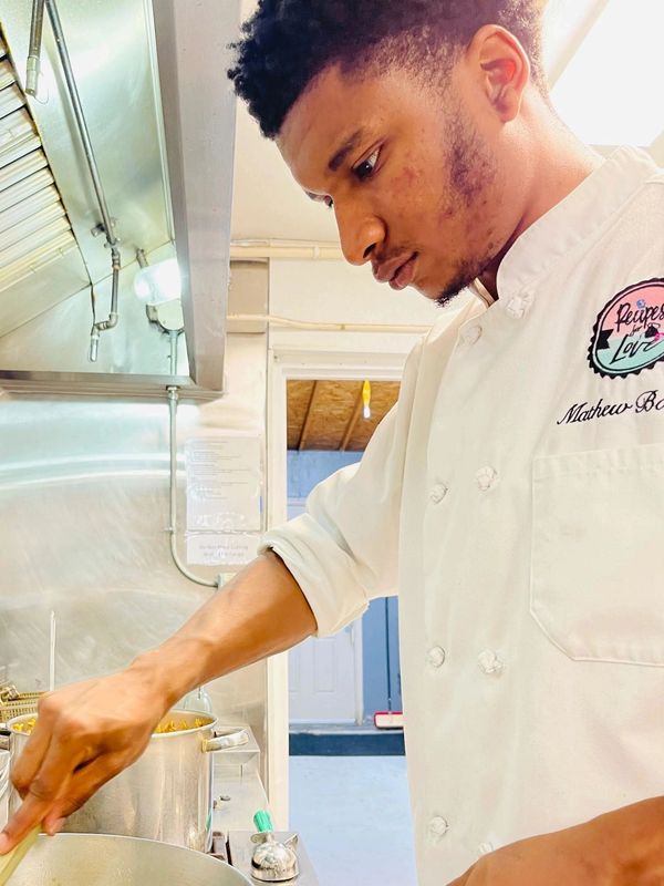 Chef in white uniform cooking in a kitchen.