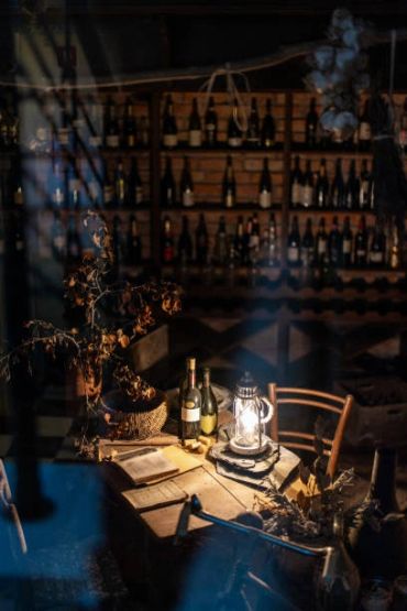 Cozy wine cellar with wooden table and lantern.
