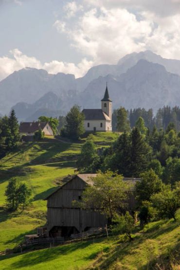 Scenic village with church on hill and mountains.