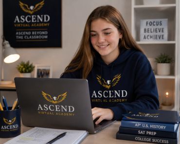 Smiling student studying online with Ascend Virtual Academy laptop and hoodie.