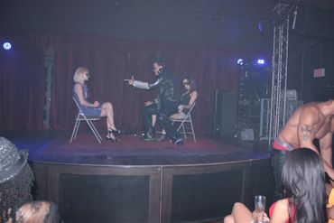 Male stripper in leather jacket on stage with 2 women in chairs. Male strippers Scottsdale, Arizona