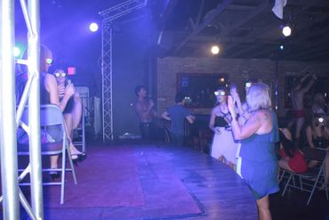 Arizona Male Strippers, picture of strip club with 3 women standing at front of stage taking photos.