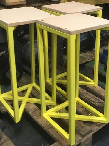 Yellow metal work with wooden seat. Fabrication of a set of stools