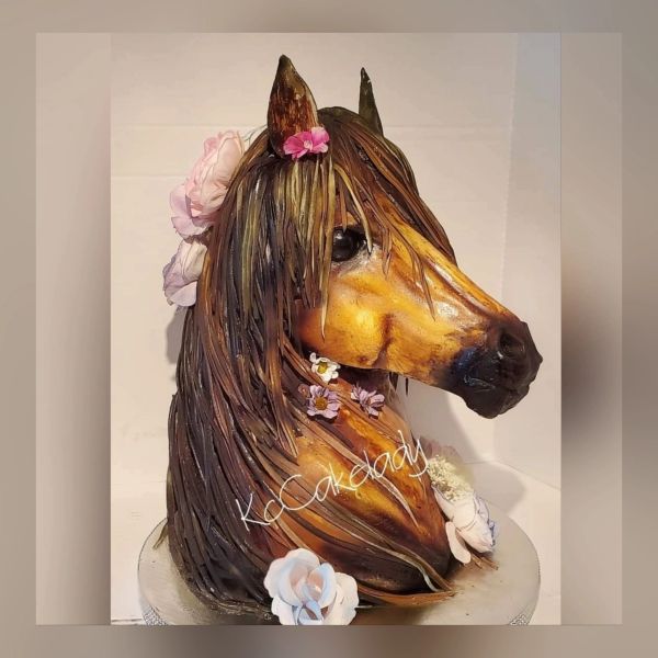 Realistic horse head cake with floral decorations.