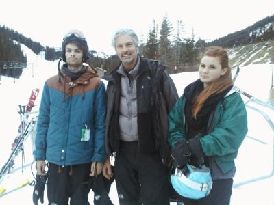Three people posing in ski gear on a snowy slope.