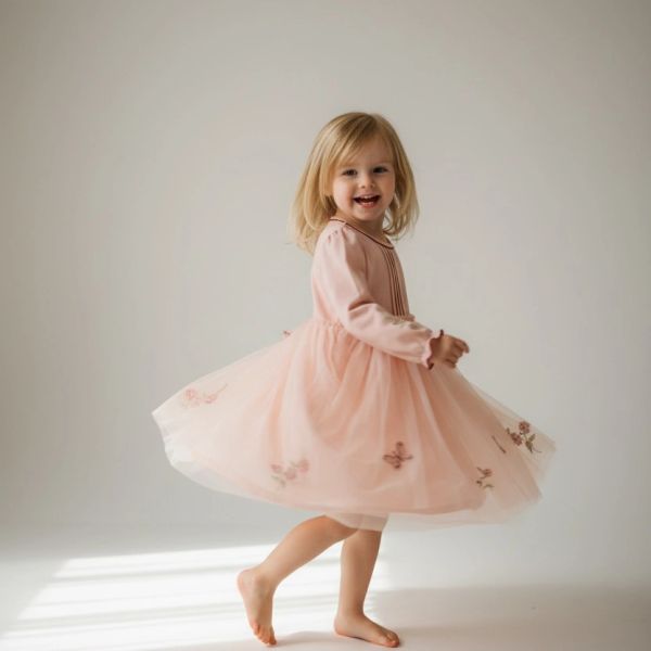 Young girl twirling in a pink dress.