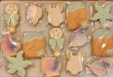 Decorated ocean-themed cookies for a baby shower, individually wrapped.