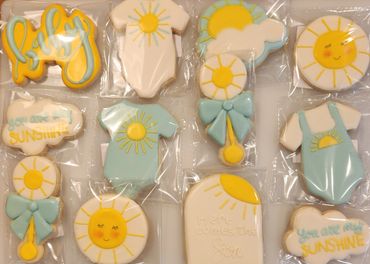 Decorative baby-themed cookies with sun and sunshine designs.