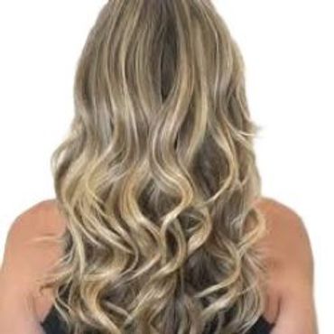 Long wavy blonde hair with highlights seen from the back.